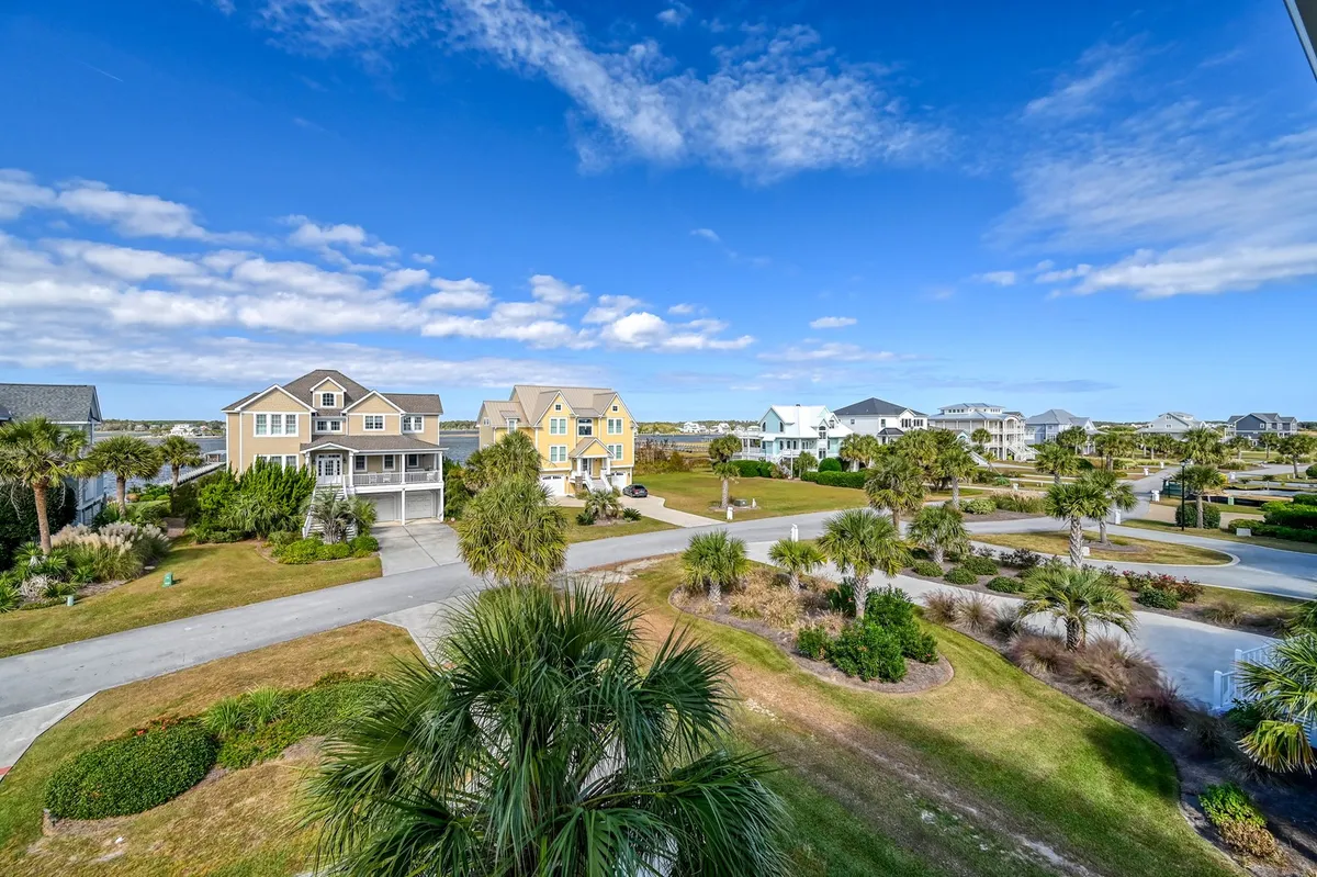 This exterior image features colorful houses with palm trees, well-manicured lawns, and wide, pedestrian-friendly streets. The vibrant neighborhood scene suggests a relaxing, inviting environment ideal for exploring with a pet. The visible green space and walkways evoke a sense of safety and openness, perfect for long strolls and worry-free exploration with a dog.